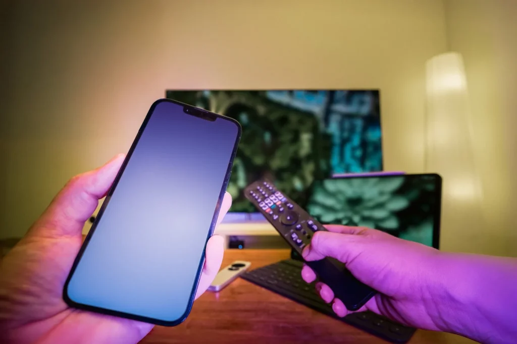 Phone and TV remote used to test streaming across multiple devices