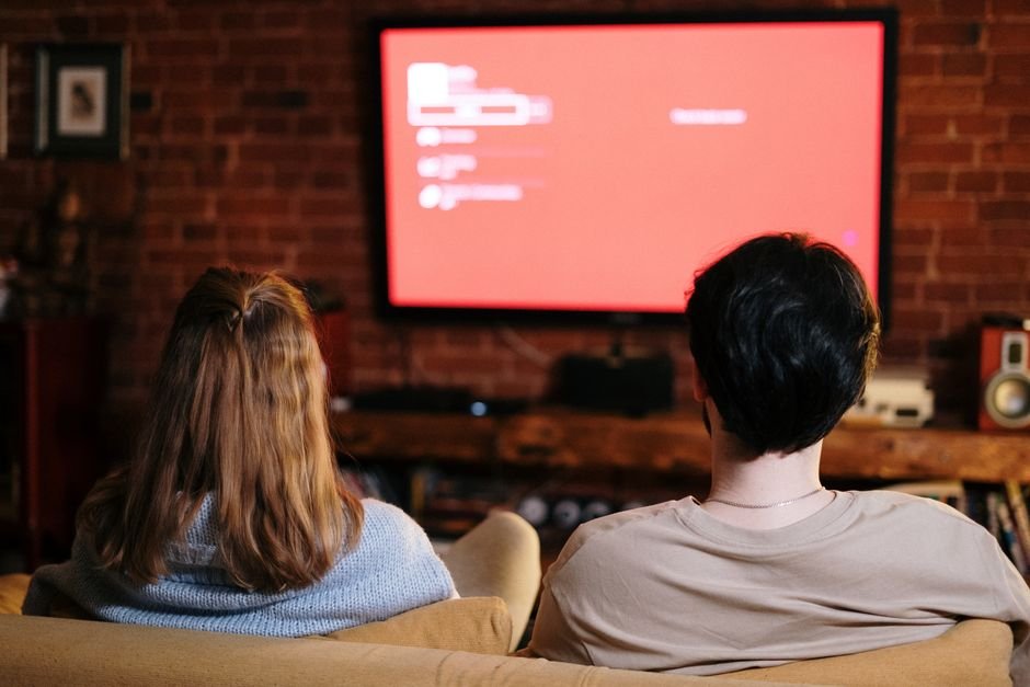 Family watching live TV on a television in a living room